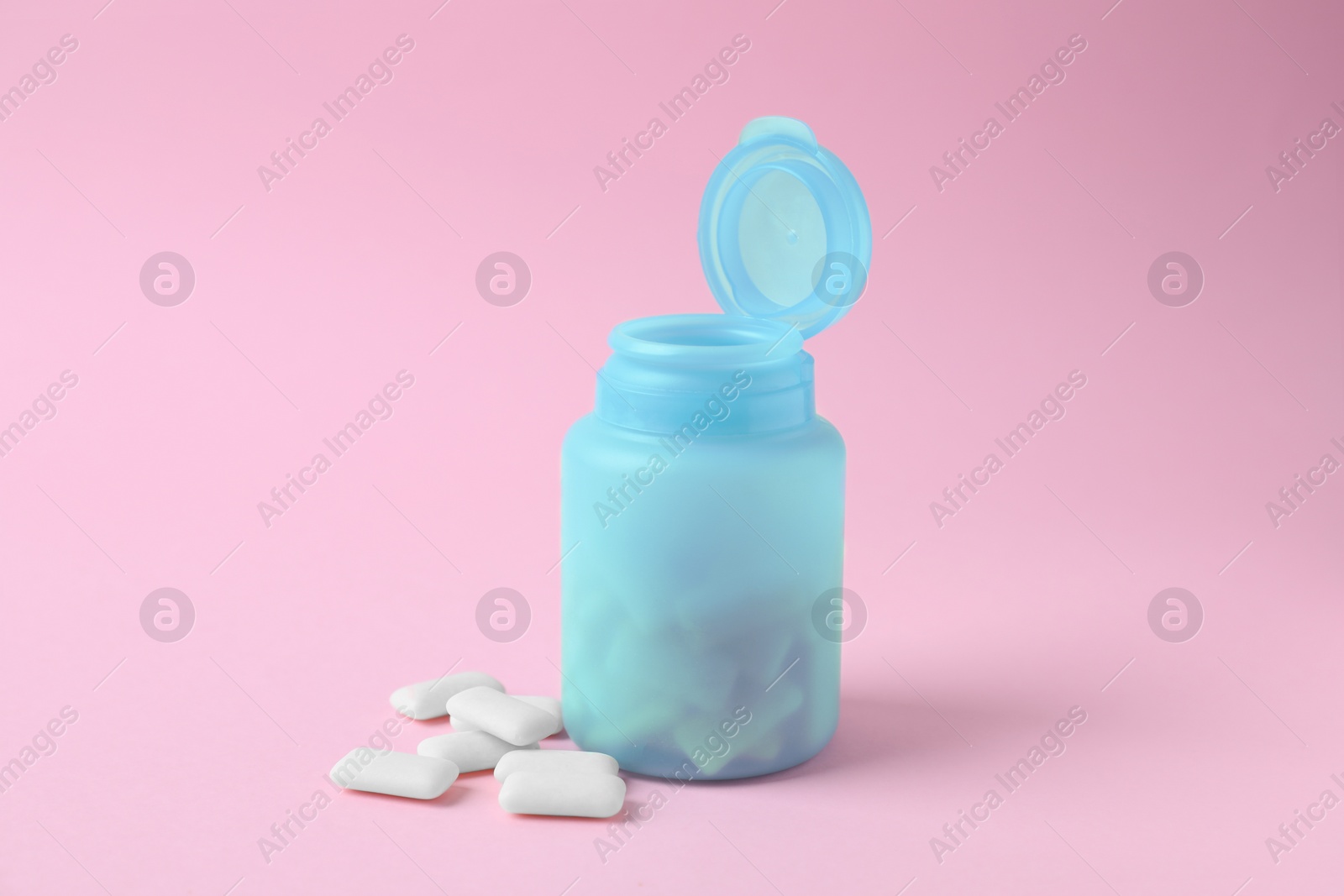 Photo of Jar with chewing gums on pink background