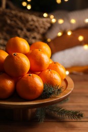 Photo of Stand with delicious ripe tangerines on wooden table