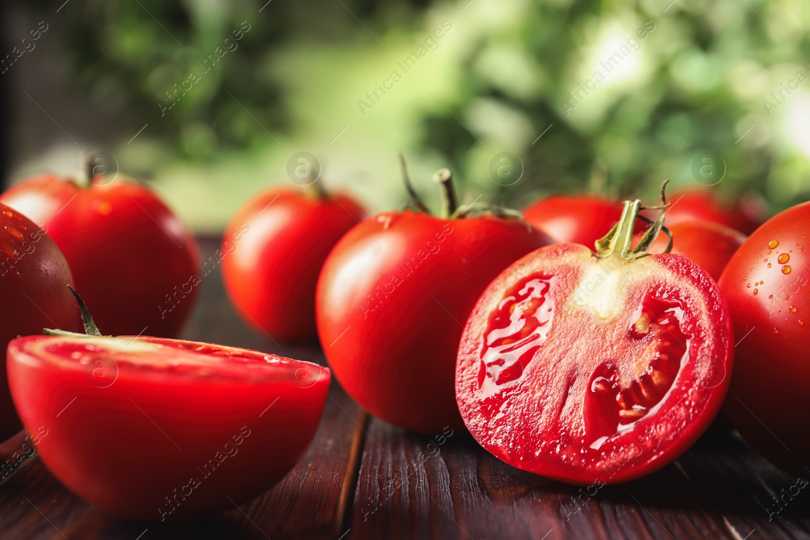 Photo of Fresh ripe red tomatoes on wooden table