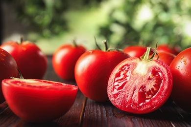 Photo of Fresh ripe red tomatoes on wooden table