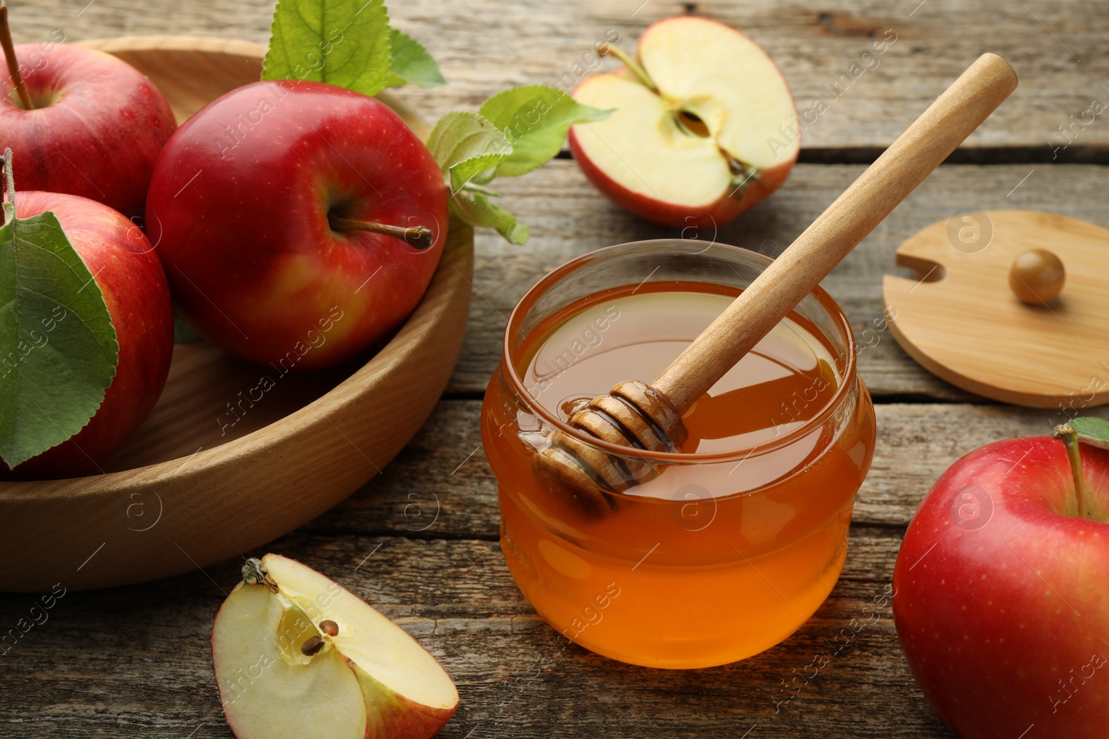 Photo of Sweet honey and fresh apples on wooden table, closeup