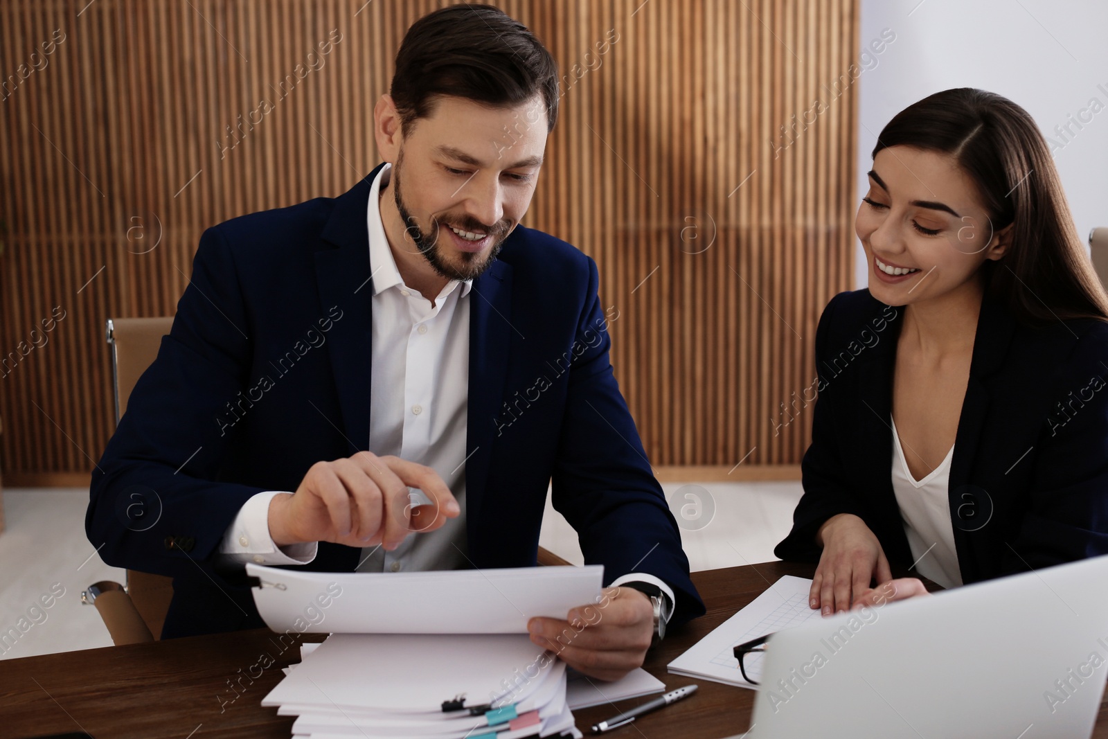 Photo of Office employees working with documents at table indoors