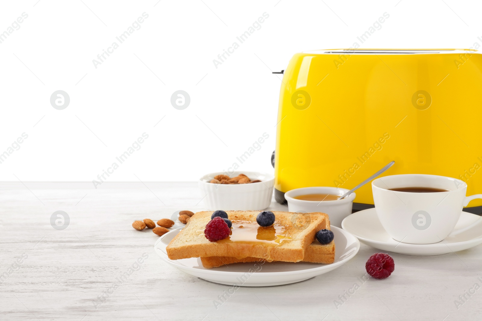 Photo of Delicious breakfast with toasted bread and berries served on wooden table against white background. Space for text