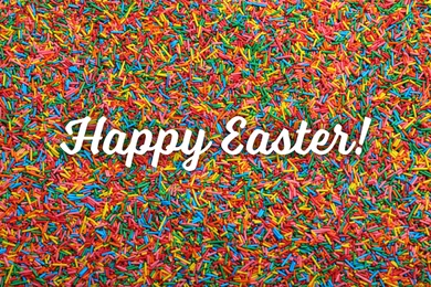 Image of Text Happy Easter and bright colorful sprinkles as background, top view. Confectionery decor