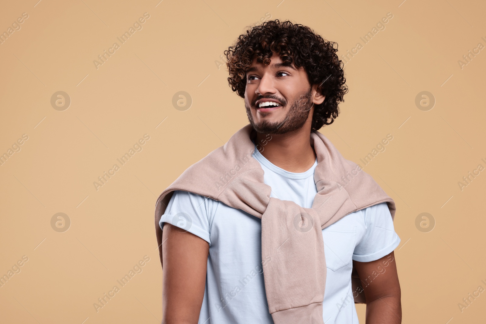 Photo of Handsome smiling man on beige background, space for text