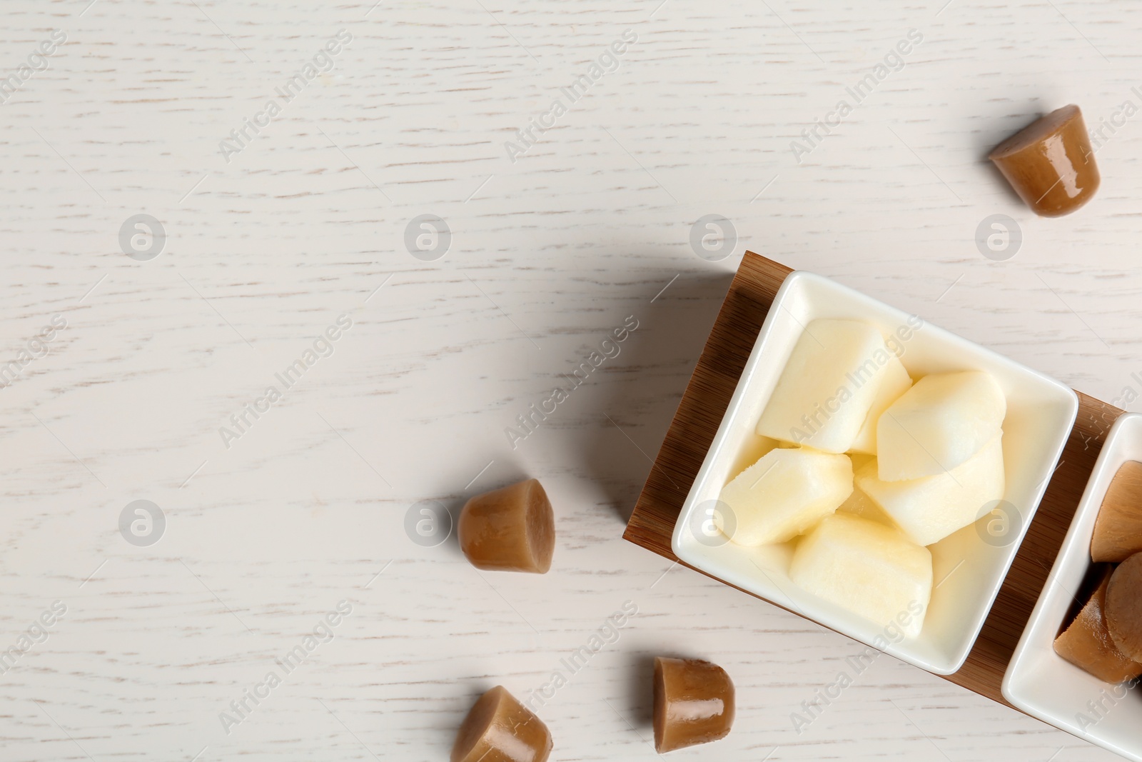 Photo of Flat lay composition with milk and coffee ice cubes on white wooden background. Space for text