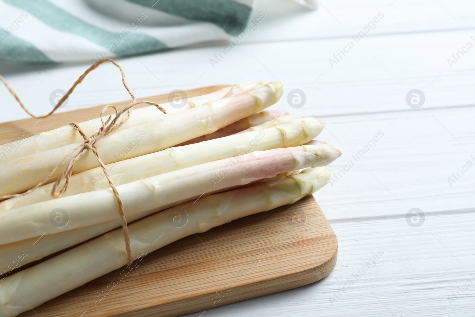 Photo of Fresh white asparagus on wooden table, closeup