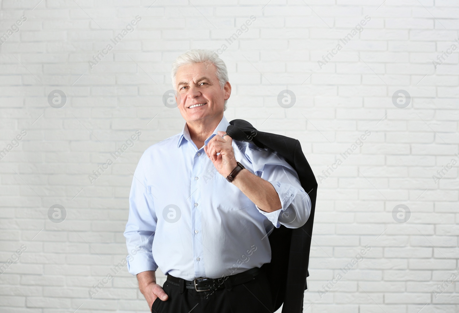 Photo of Portrait of handsome mature man near brick wall