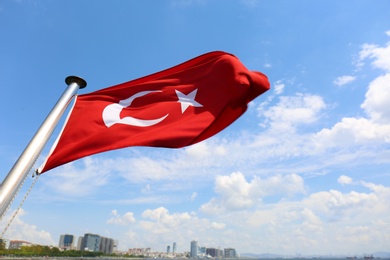 Photo of Turkish flag and beautiful city on background