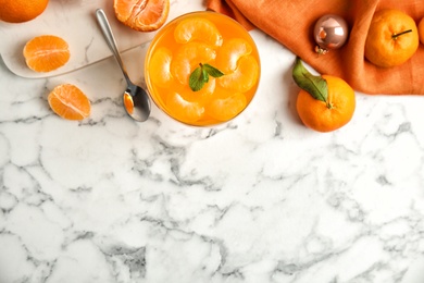 Photo of Delicious tangerine jelly and fresh fruits on white marble table, flat lay. Space for text