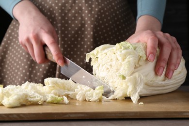 Photo of Healthy food. Woman cutting Chinese cabbage at grey table, closeup