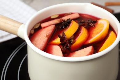 Photo of Delicious hot mulled wine in pot, closeup