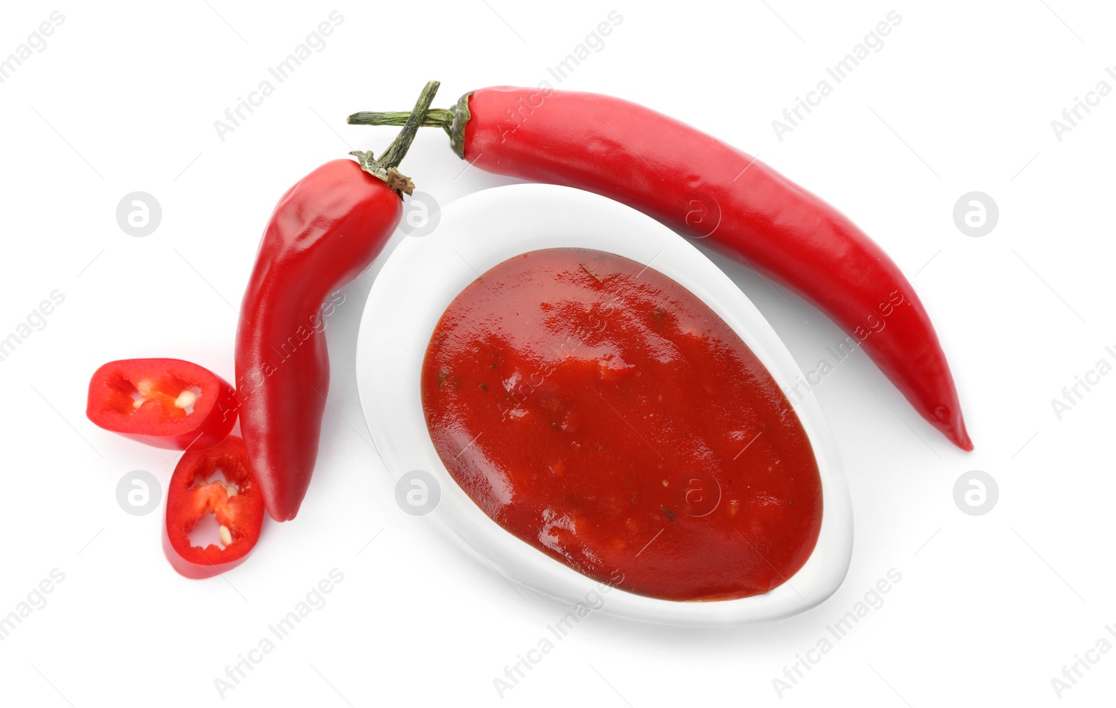 Photo of Gravy boat with spicy chili sauce and fresh pepper on white background, top view