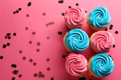 Photo of Delicious cupcakes with bright cream and confetti on pink background, flat lay. Space for text