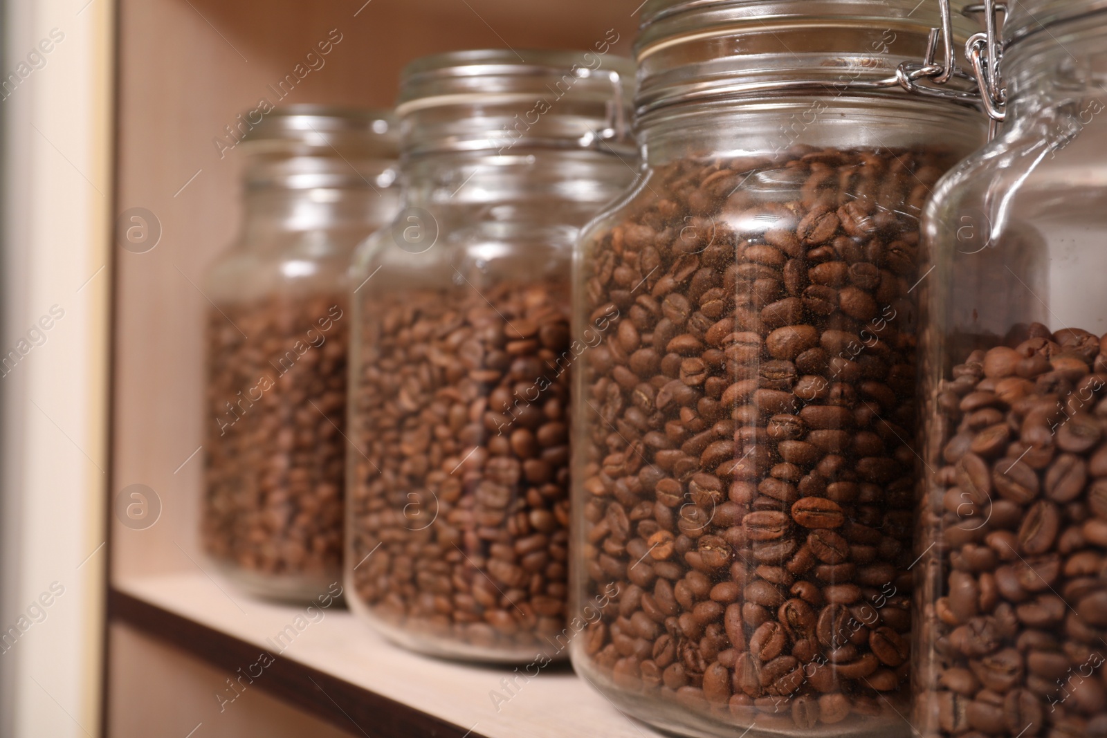 Photo of Glass jars with coffee beans on rack, space for text