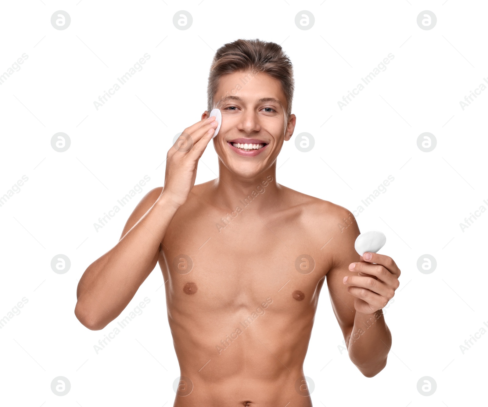 Photo of Handsome man cleaning face with cotton pad on white background