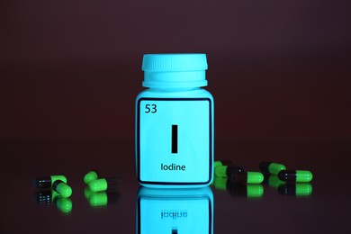 Photo of Bottlemedical iodine and pills on brown background, color tone effect