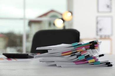 Photo of Stack of documents with paper clips on office table. Space for text