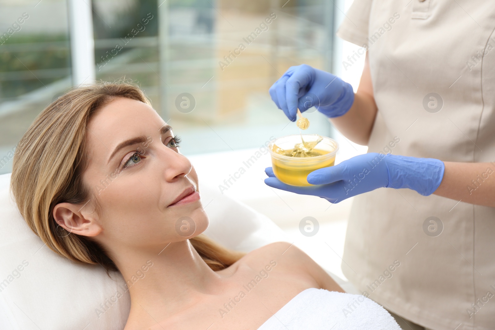 Photo of Beautiful woman getting wax epilation in salon