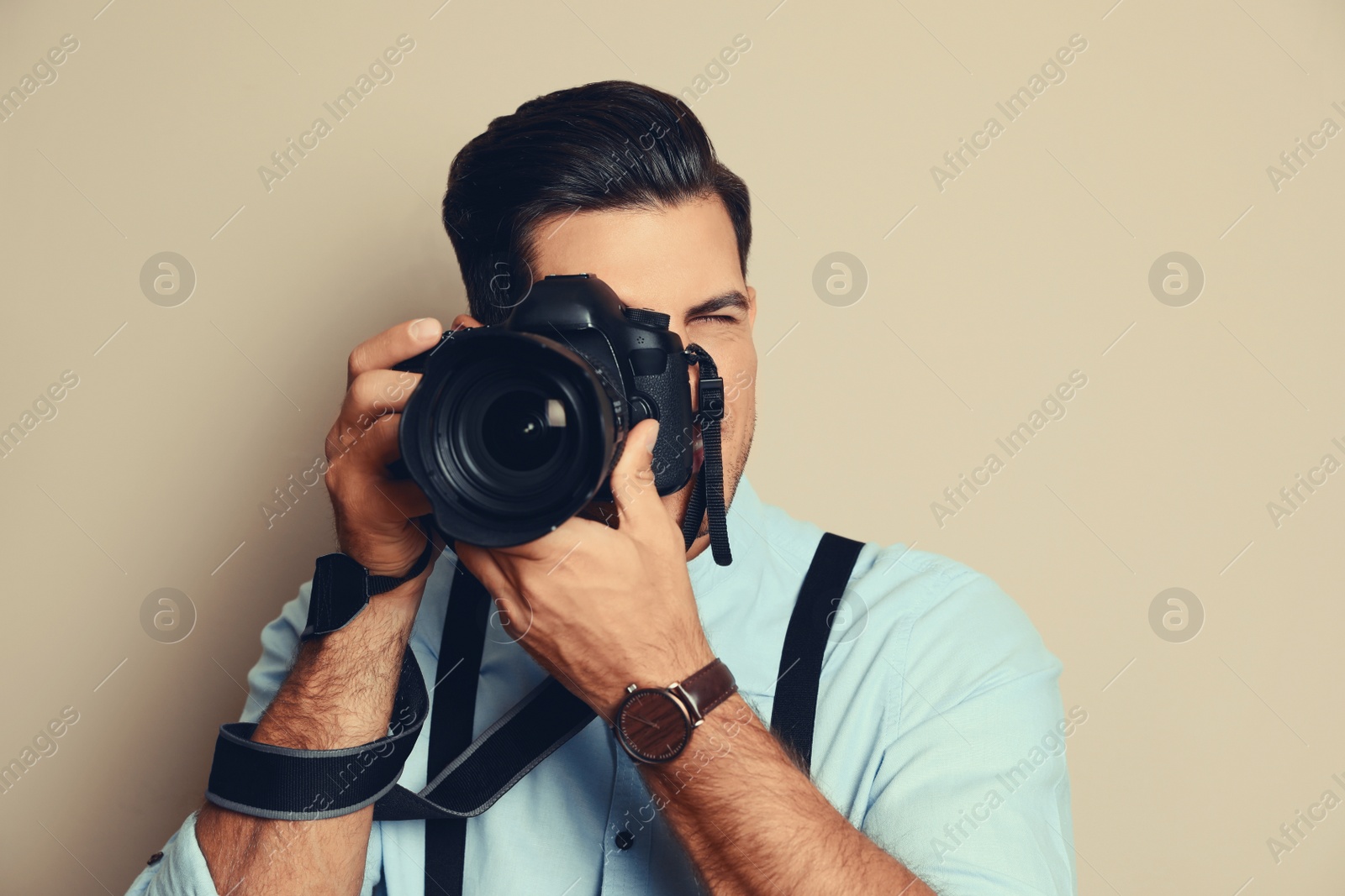 Image of Professional photographer with camera on beige background