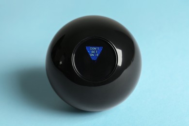 Photo of Magic eight ball with prediction Don't Be On It on light blue background
