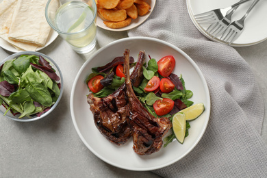 Photo of Delicious grilled ribs served on light grey table, flat lay