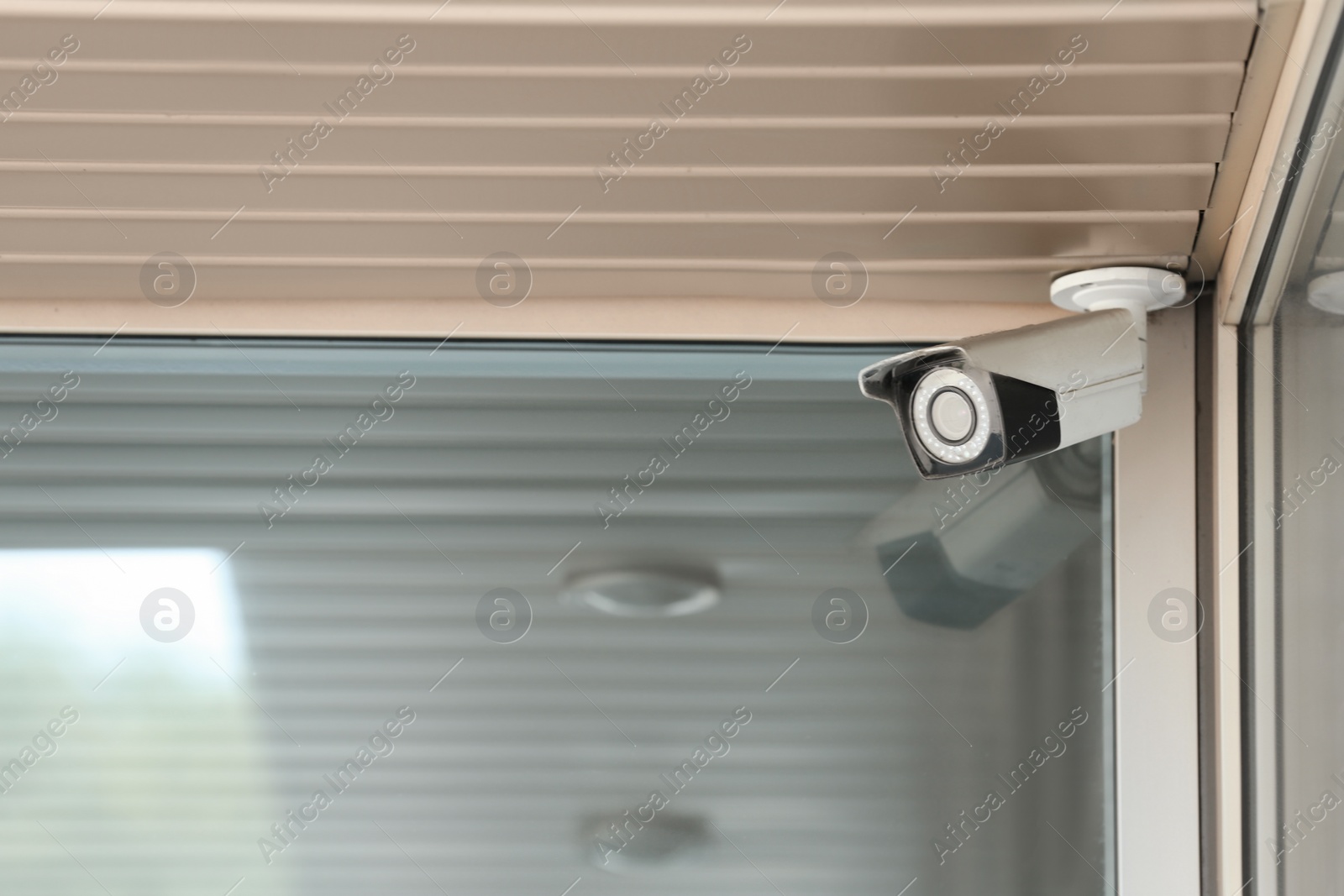 Photo of Modern CCTV security camera on building wall outdoors. Space for text