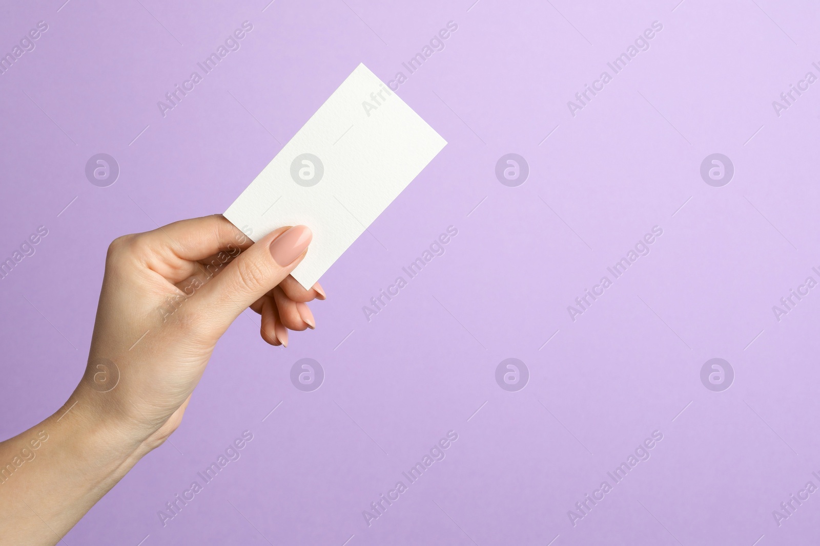 Photo of Woman holding blank business card on violet background, closeup. Mockup for design