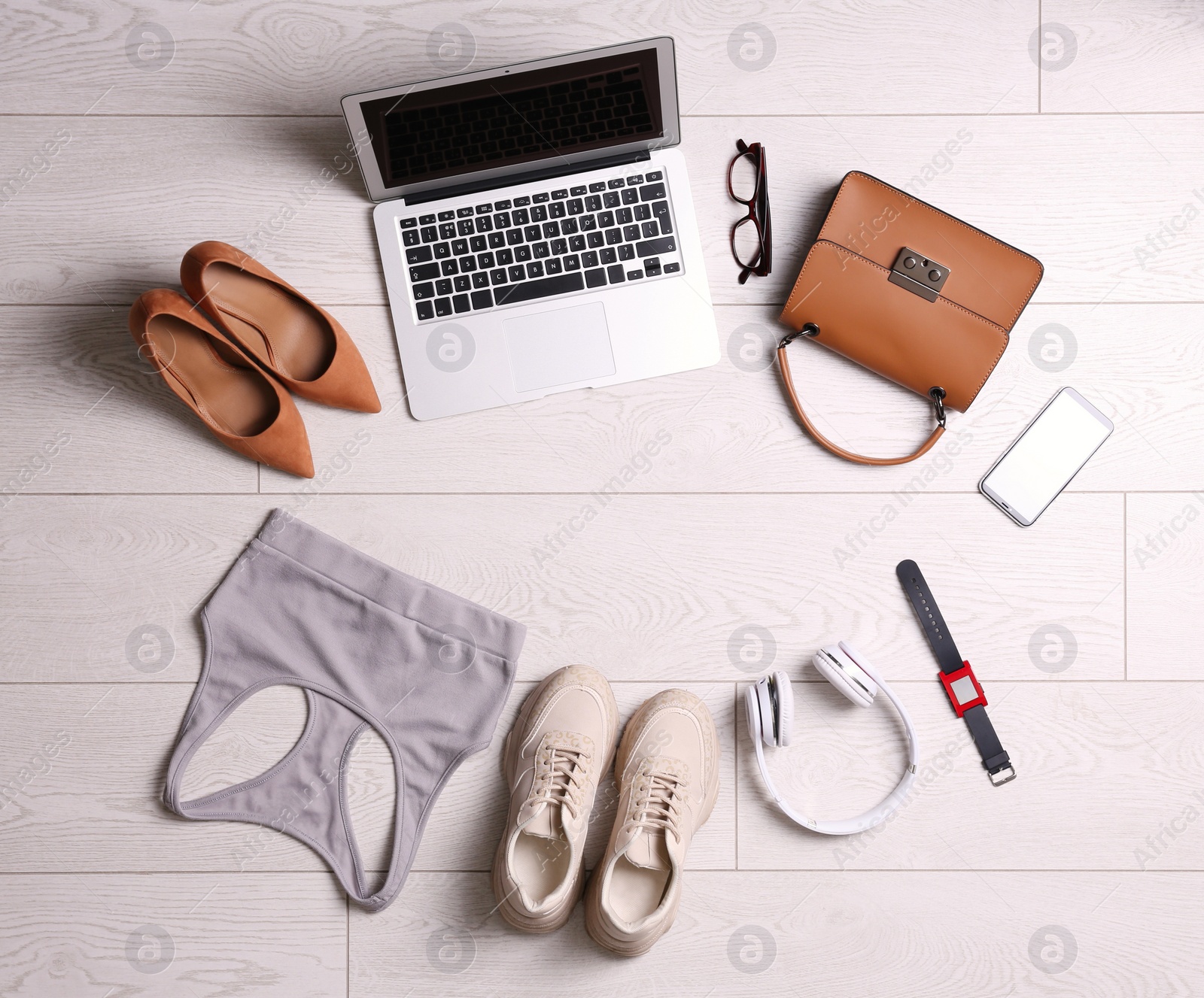 Photo of Flat lay composition with business supplies and sport equipment on white wooden floor. Concept of balance between work and life