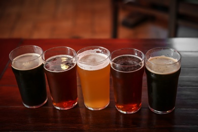 Glasses of different beer on table indoors