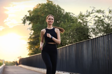 Photo of Attractive sporty woman in fitness clothes jogging outdoors