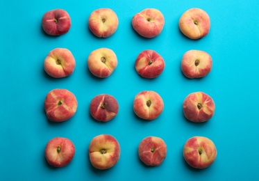 Photo of Fresh donut peaches on blue background, flat lay