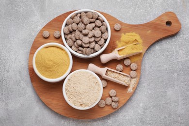 Different types of brewer's yeast on grey table, top view