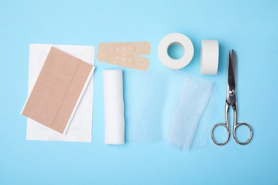 Photo of White bandage and medical supplies on light blue background, top view
