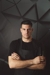 Photo of Hairdresser with professional tools on dark background