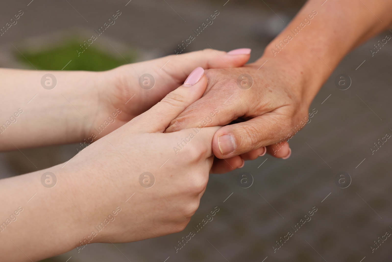 Photo of Trust and support. Women joining hands outdoors, closeup