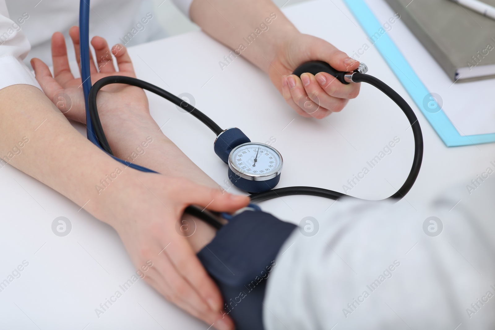 Photo of Doctor checking blood pressure of woman in clinic, closeup