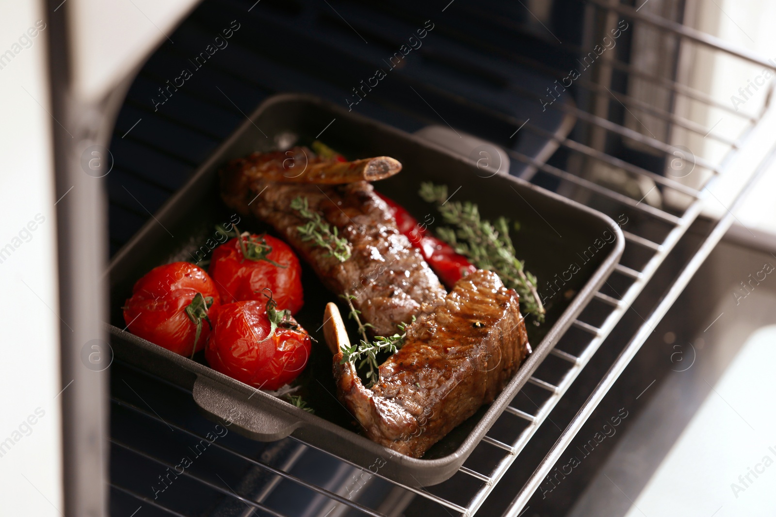 Photo of Delicious roasted ribs with tomatoes in oven