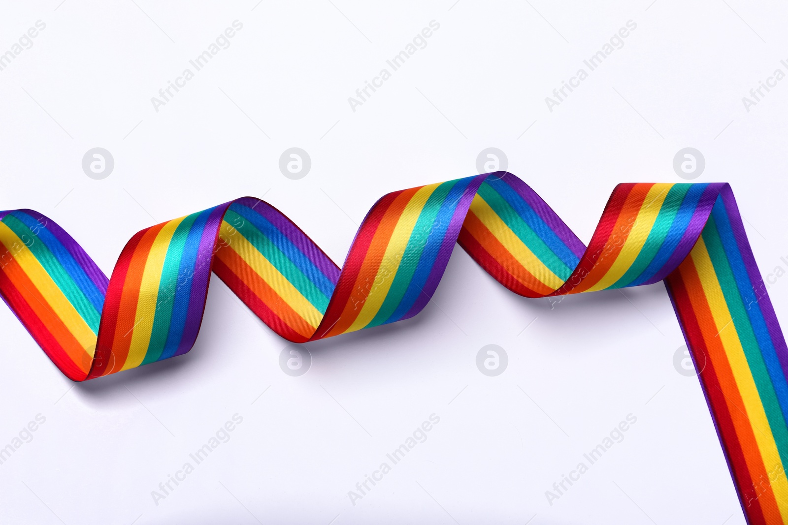 Photo of Rainbow ribbon on white background, top view. LGBT pride