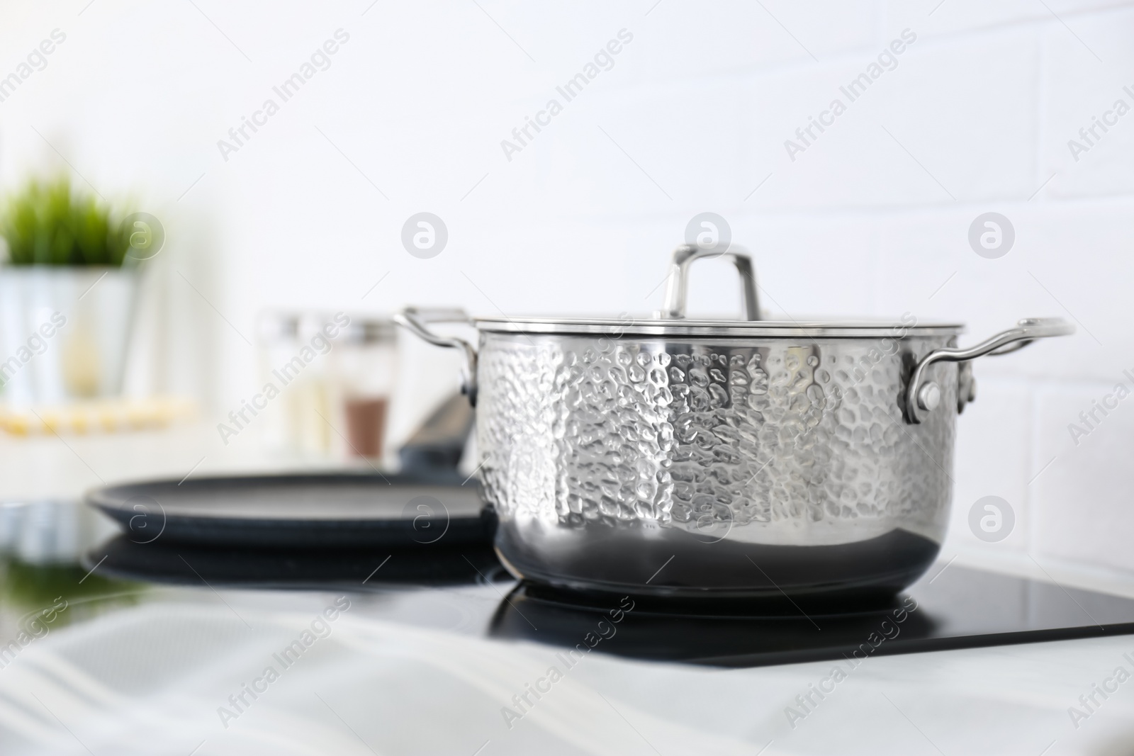 Photo of New shiny saucepan on stove in kitchen