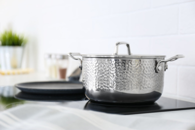 New shiny saucepan on stove in kitchen