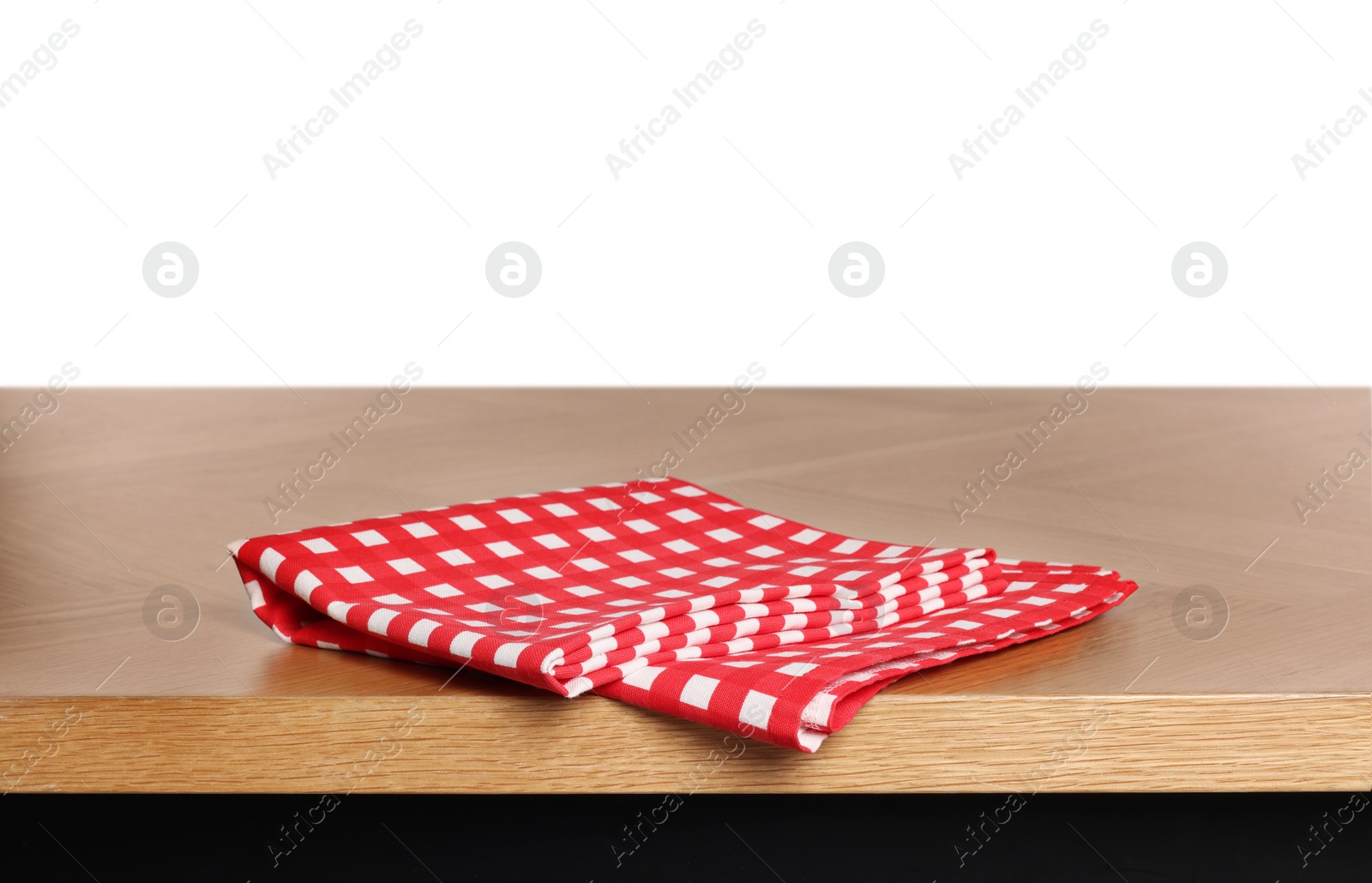 Photo of Checkered tablecloth on wooden table against white background