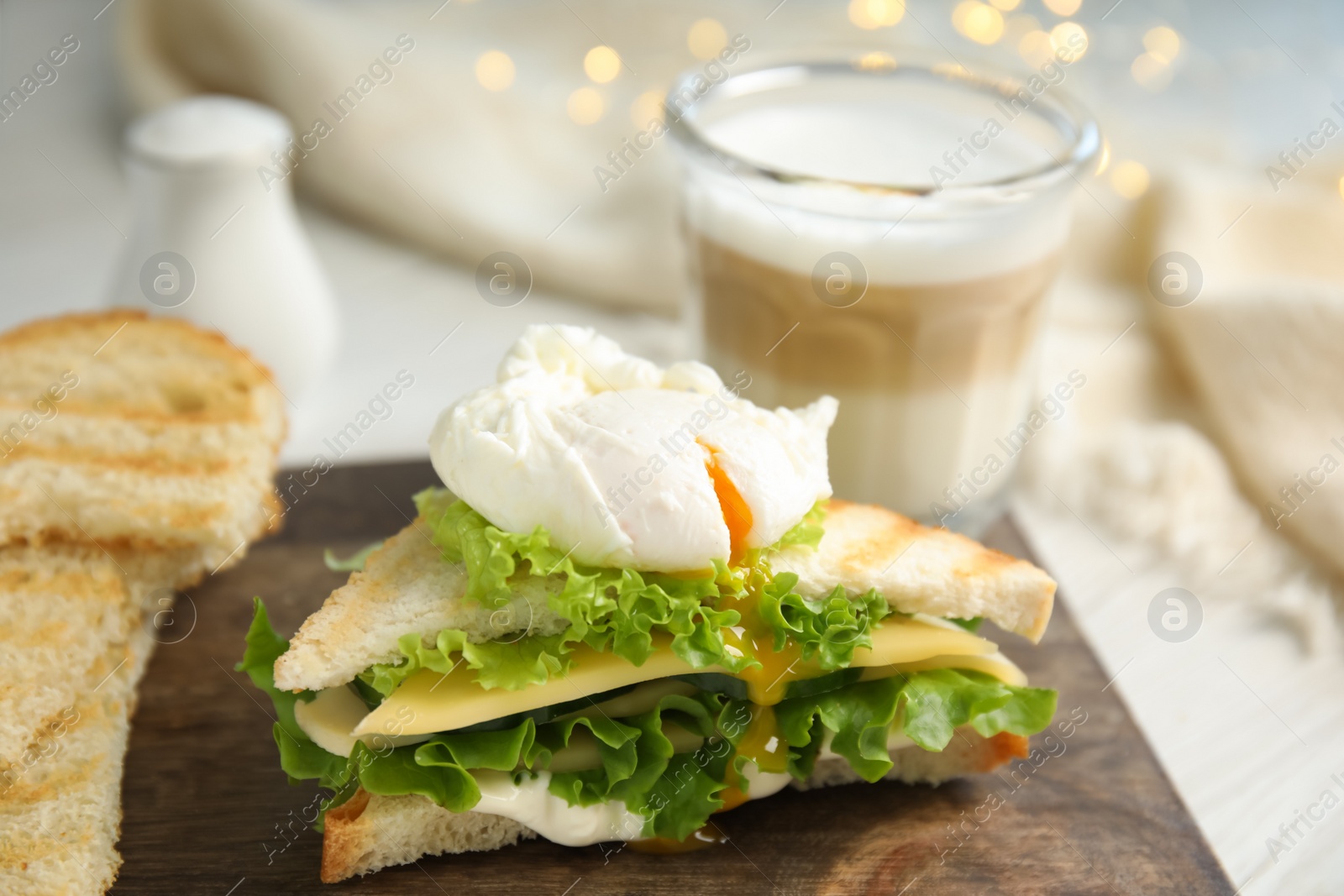 Photo of Delicious sandwich with vegetables and poached egg on table, closeup