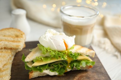 Photo of Delicious sandwich with vegetables and poached egg on table, closeup