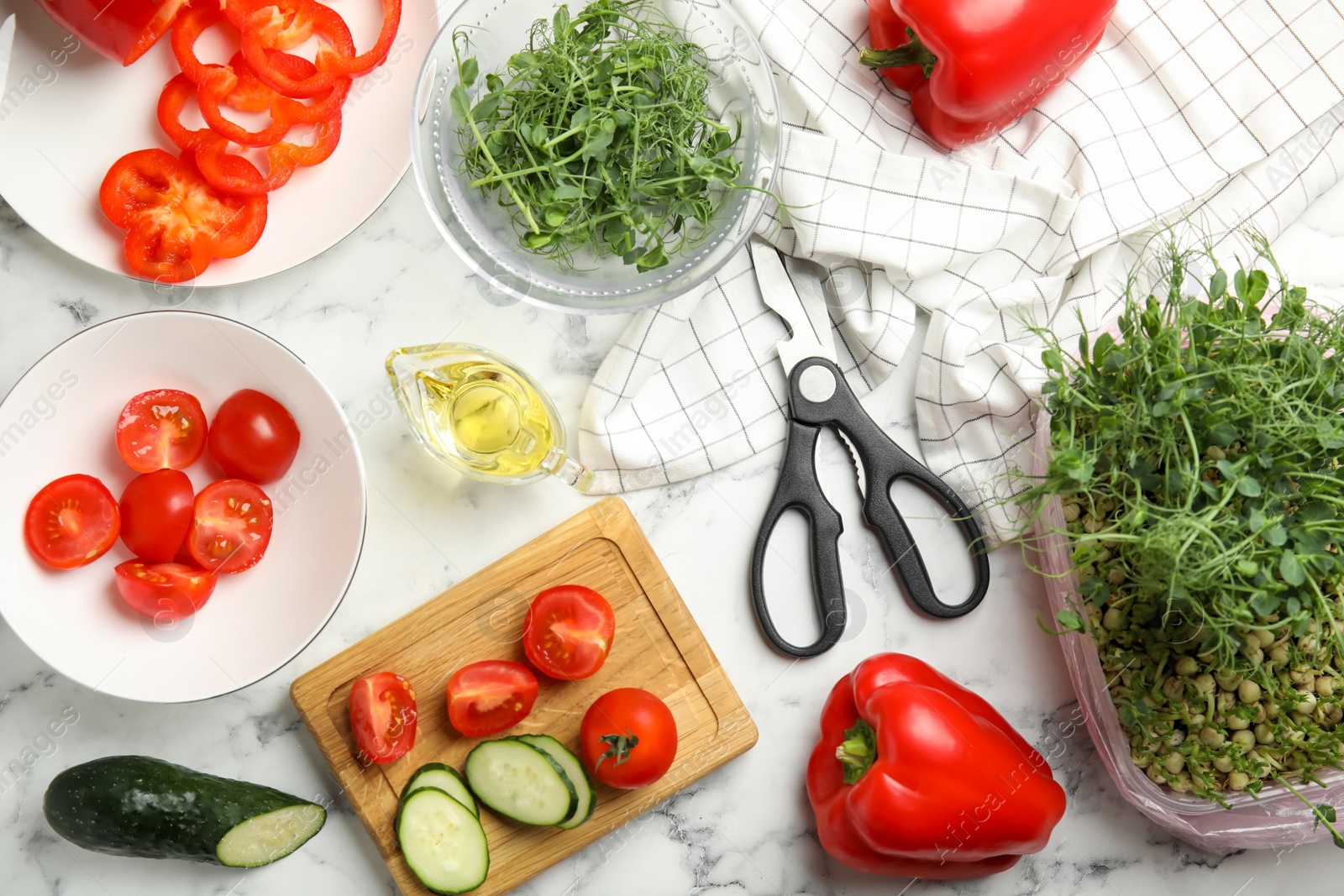 Photo of Fresh microgreen for tasty salad on white marble table, flat lay