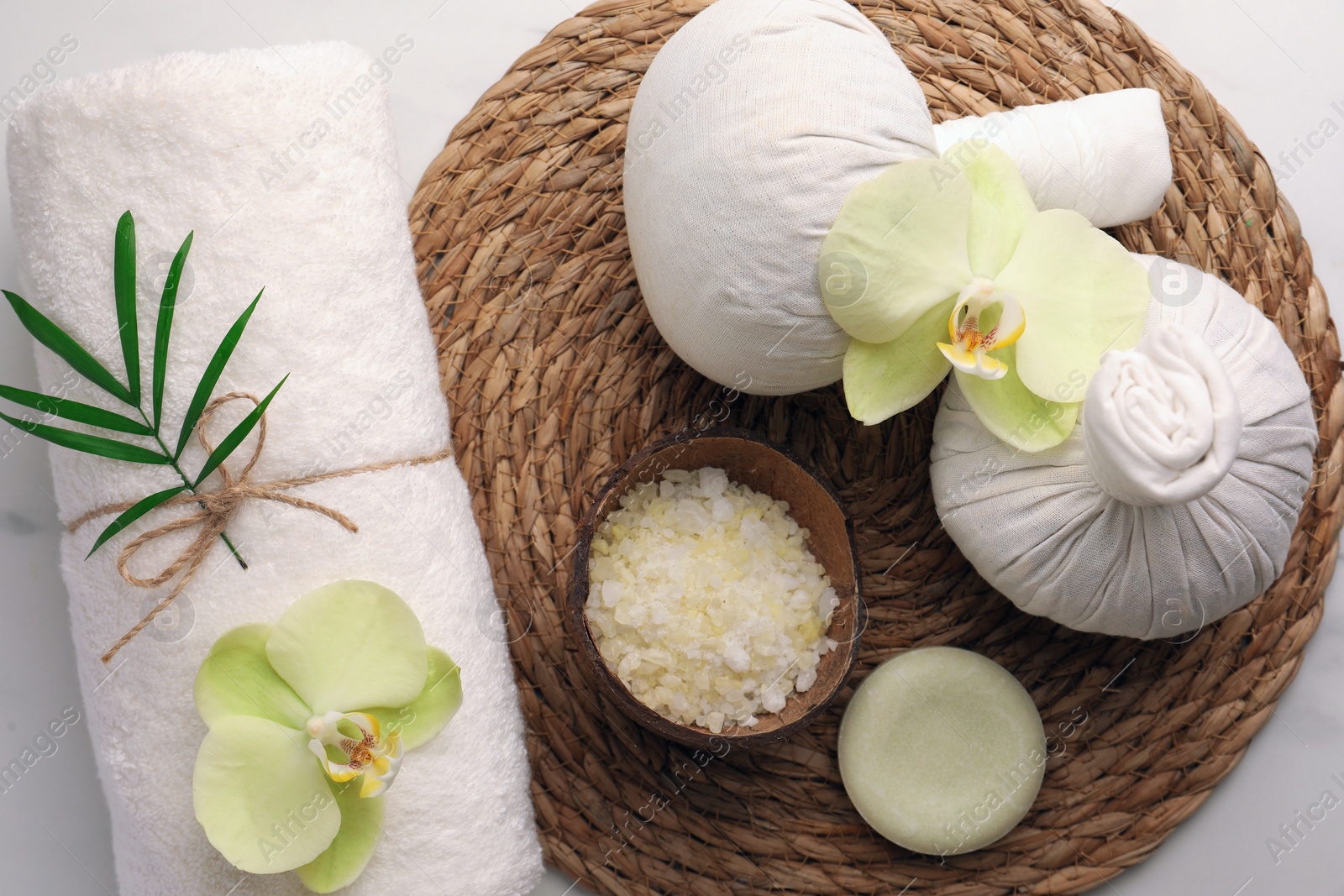 Photo of Flat lay composition with spa products and beautiful flowers on white marble table