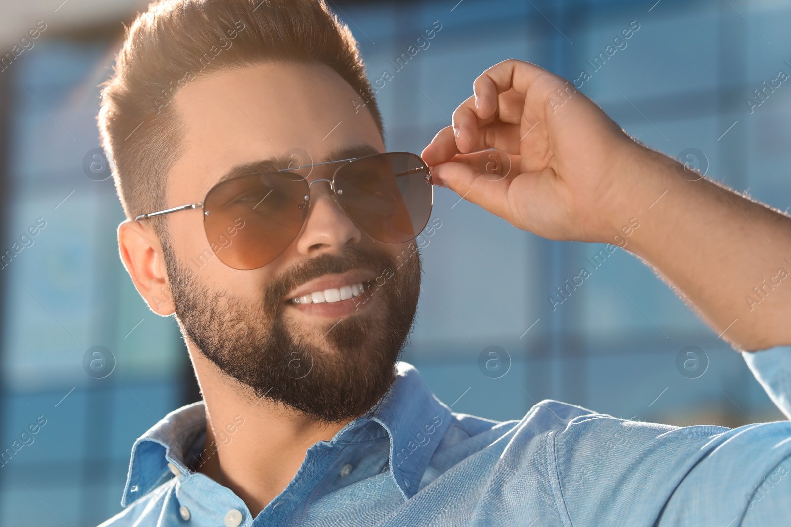 Photo of Handsome smiling man in sunglasses outdoors on sunny day