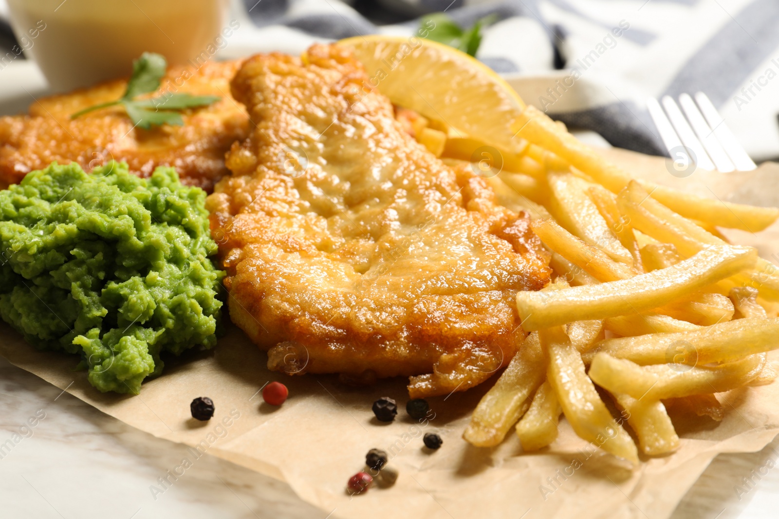 Photo of British traditional fish, potato chips and mushy peas on table, closeup