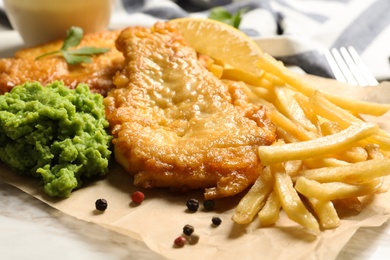 Photo of British traditional fish, potato chips and mushy peas on table, closeup