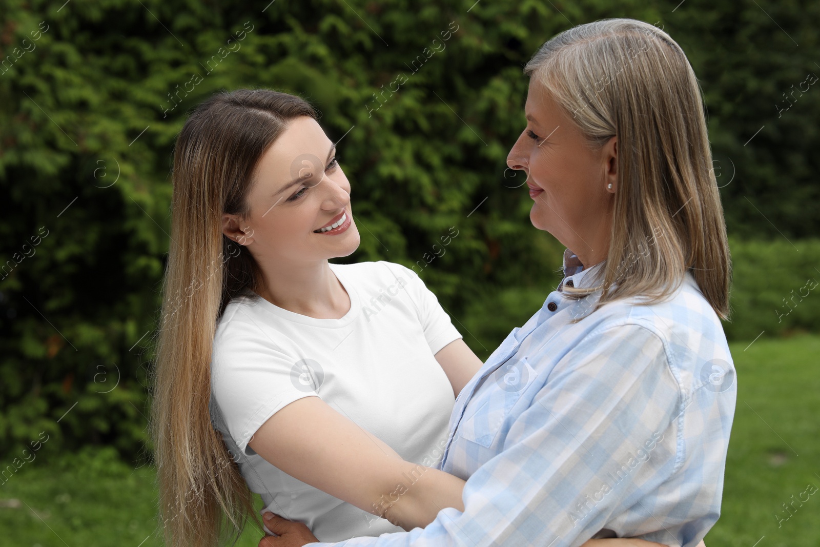 Photo of Happy mature mother and her daughter hugging in park